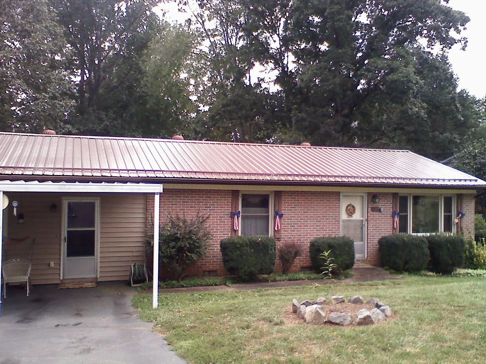 Bronze metal roof and carport on a brick ranch home — Roof Repair work by our crew in Only